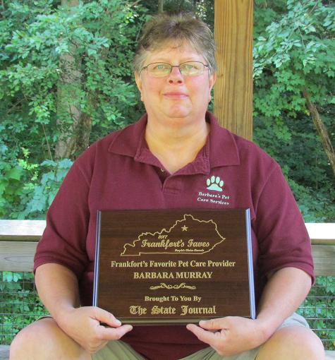 Barbara holding her plaque for being chosen as Frankfort's Favorite Pet Care Service in the State-Journal 2017 Frankfort Faves People's Choice Awards