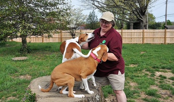 Barbara playing with two dogs of a regular client in their fenced yard.